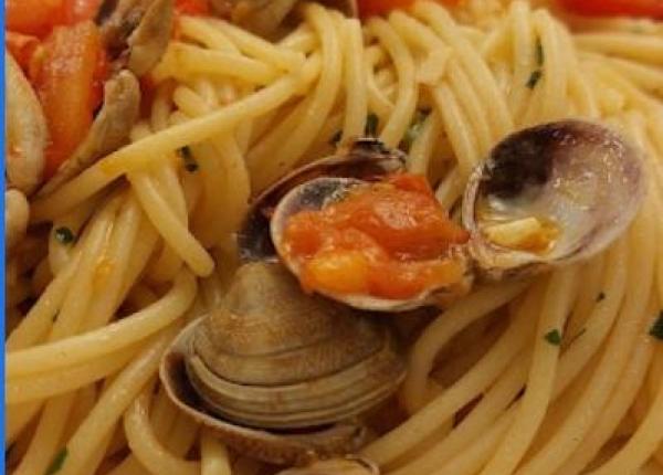 Spaghetti mit Muscheln, frischen Tomaten und Petersilie.