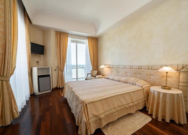 Camera elegante con letto matrimoniale e vista mare.