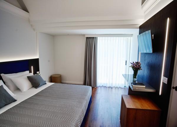 Modernes Zimmer mit Doppelbett und Wand-TV.