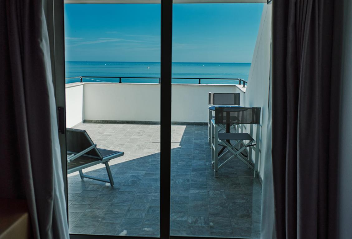 Vista mare da una terrazza con sedie.
