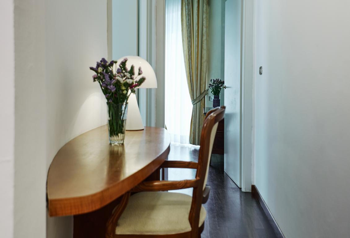 Corridoio elegante con tavolo in legno e lampada moderna.