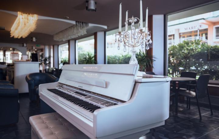 Piano blanc avec candélabre dans un salon élégant.