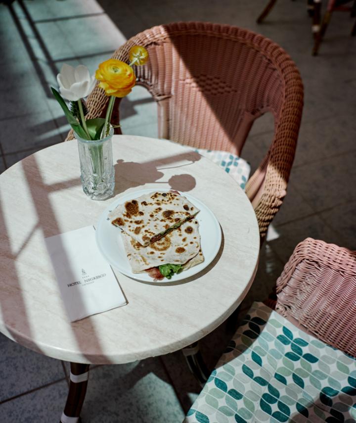 Table avec pain plat, fleurs et menu d'hôtel.