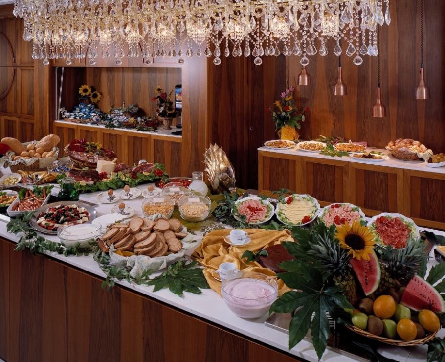 Luxurious buffet with crystal chandelier and colorful dishes.