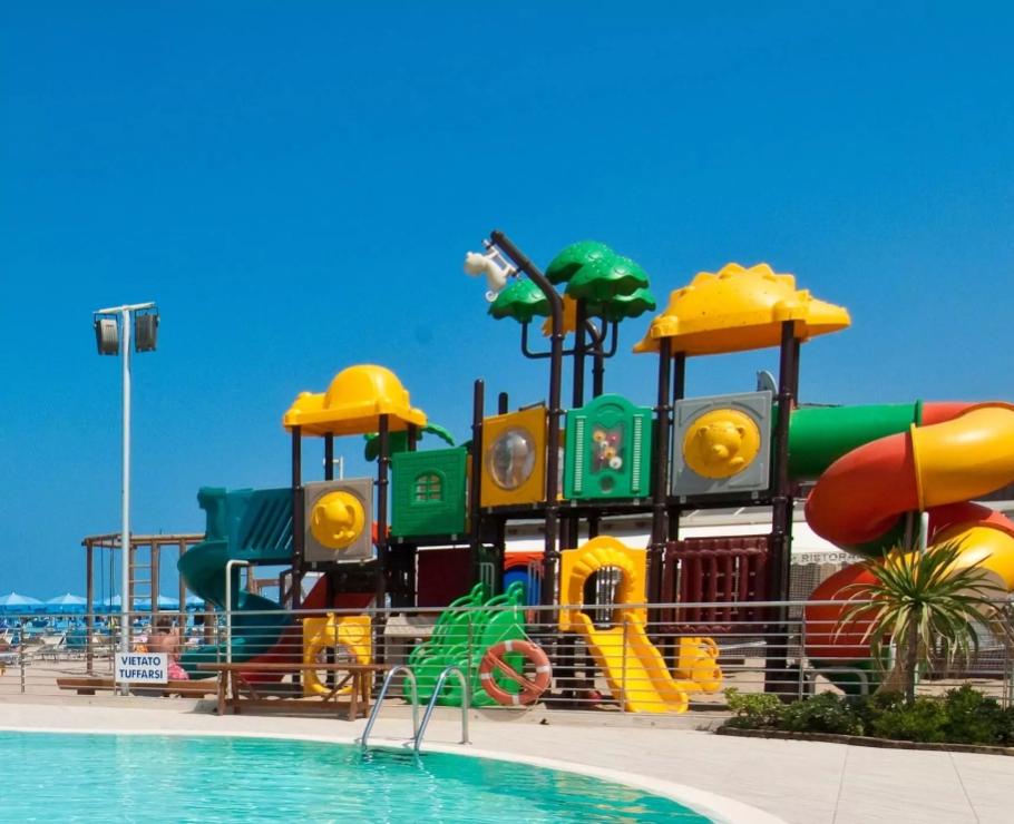 Parco giochi colorato vicino alla piscina con scivoli.
